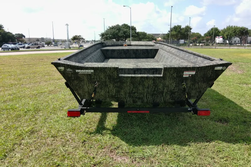 Slide: The Image of 2025 Tracker Grizzly 1860 Utility boat on grassy field, showcasing rugged design. - 23