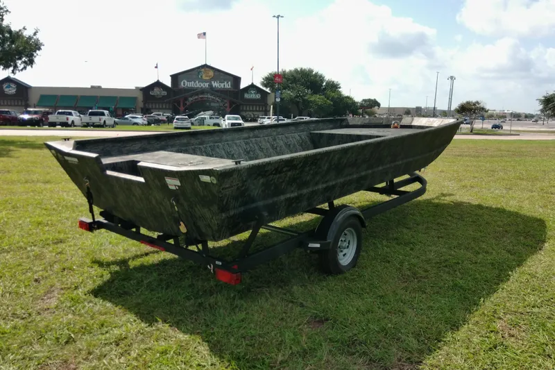 Slide: The Image of 2025 Tracker Grizzly 1860 Utility boat on trailer, parked on grass near Outdoor World. - 24