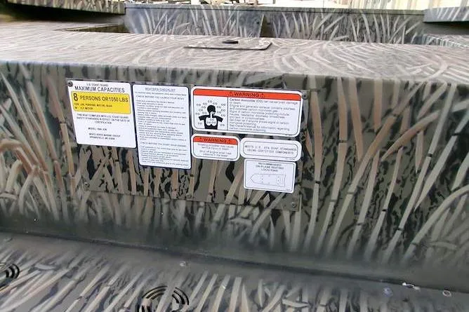 Slide: The Image of 2025 Tracker Grizzly 1860 Utility boat with camouflage design and safety labels. - 5
