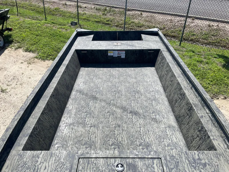 Slide: The Image of 2025 Tracker GRIZZLY 1860 Utility boat with camouflage interior, parked on grass. - 12