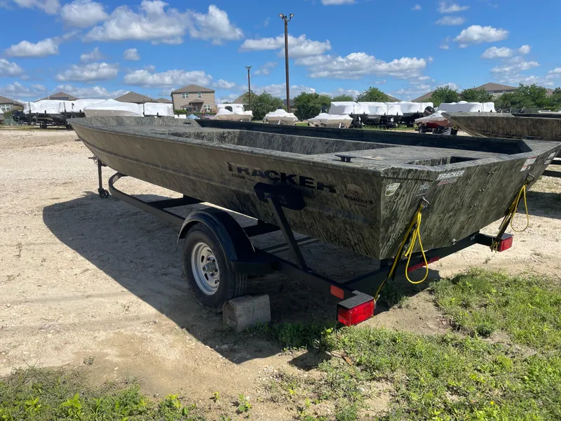 Slide: The Image of 2025 Tracker GRIZZLY 1860 Utility boat on trailer, parked outdoors under blue sky. - 4