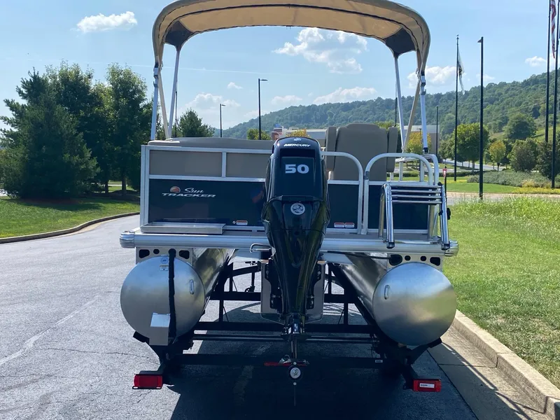 Slide: The Image of 2025 Sun Tracker Bass Buggy 16 XL Select pontoon boat with canopy and outboard motor. - 4