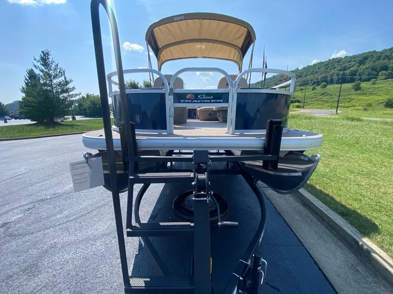 Slide: The Image of 2025 Sun Tracker Bass Buggy 16 XL Select pontoon boat on trailer, sunny day. - 5