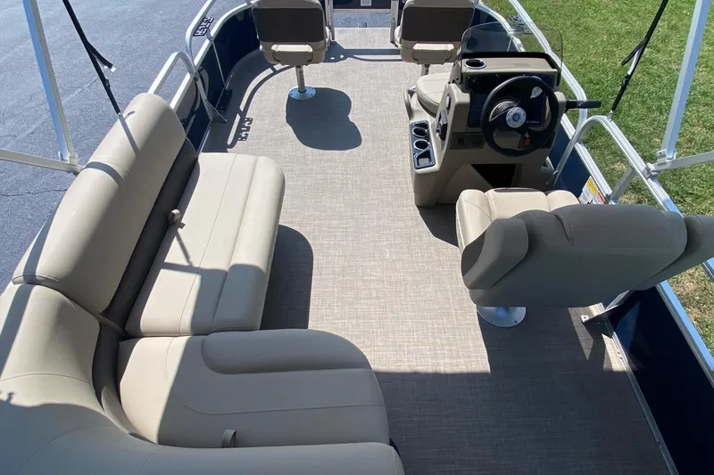 Slide: The Image of 2025 Sun Tracker Bass Buggy 16 XL Select pontoon boat interior with beige seating and steering console. - 9