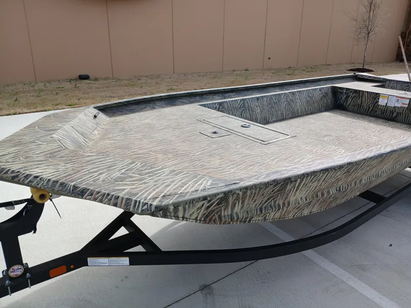 Slide: The Image of 2025 Tracker GRIZZLY 1860 Utility boat on trailer, featuring a camouflage design. - 3