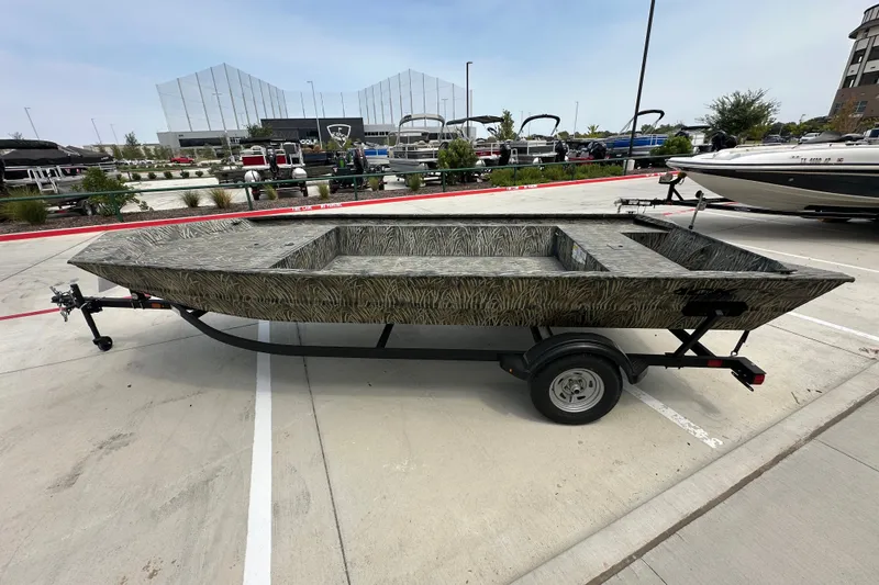 Slide: The Image of 2025 Tracker Grizzly 1860 Utility boat on trailer, parked outdoors in a marina setting. - 17