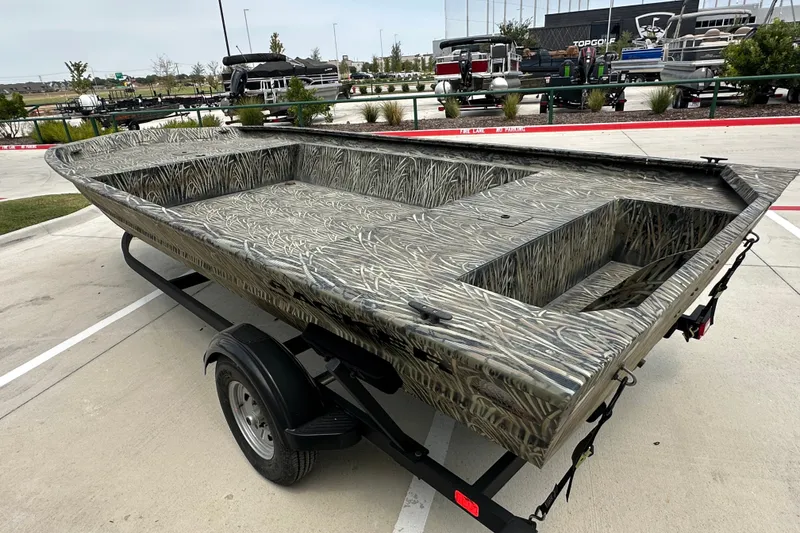 Slide: The Image of 2025 Tracker Grizzly 1860 Utility boat on trailer, featuring camouflage design. - 16