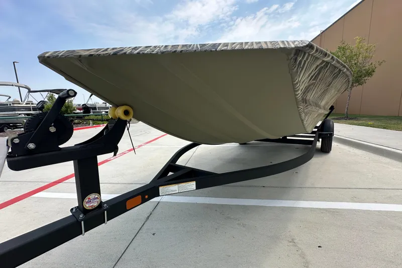 Slide: The Image of 2025 Tracker Grizzly 1860 Utility boat on trailer, parked outdoors. - 19