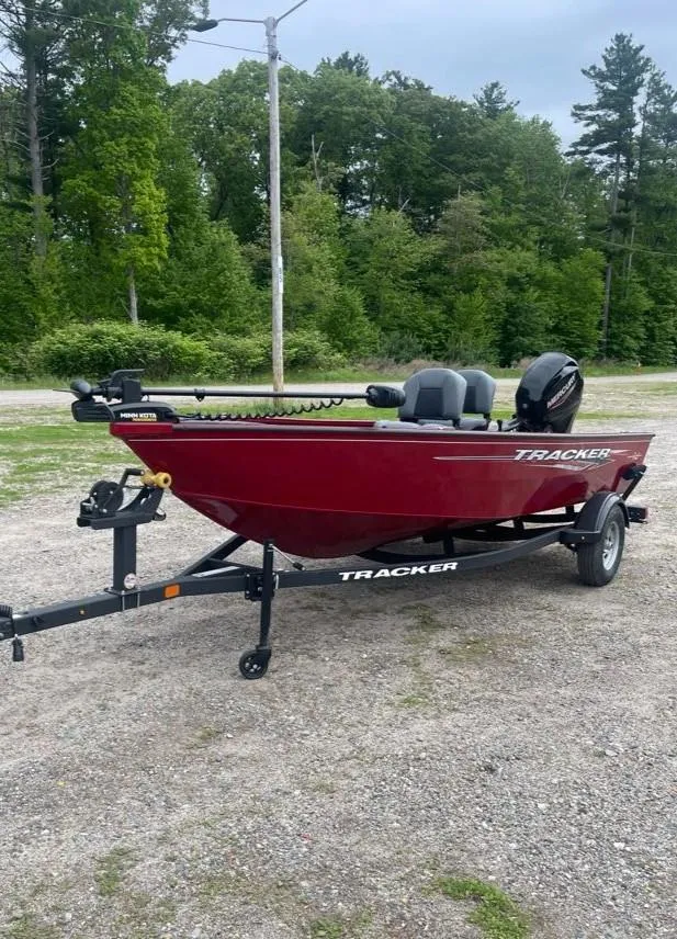 Slide: The Image of 2025 Tracker Super Guide V-16 T boat on trailer, parked outdoors. - 2