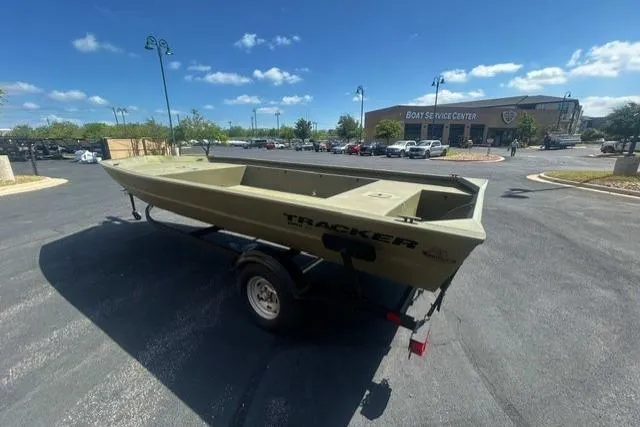 The Image of 2025 Tracker Grizzly 1860 Utility boat on trailer in parking lot, sunny day. - 0