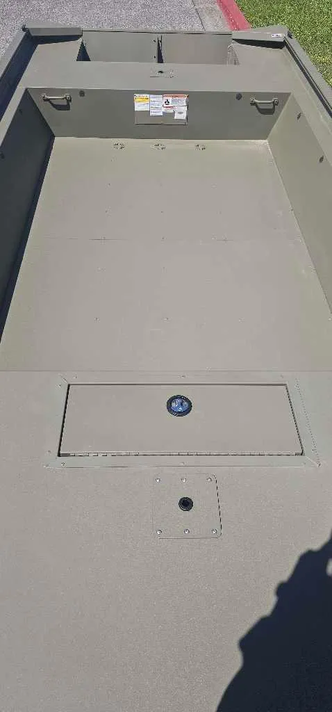 Slide: The Image of 2025 Tracker Grizzly 1860 Utility boat interior, showcasing spacious deck and storage compartment. - 3