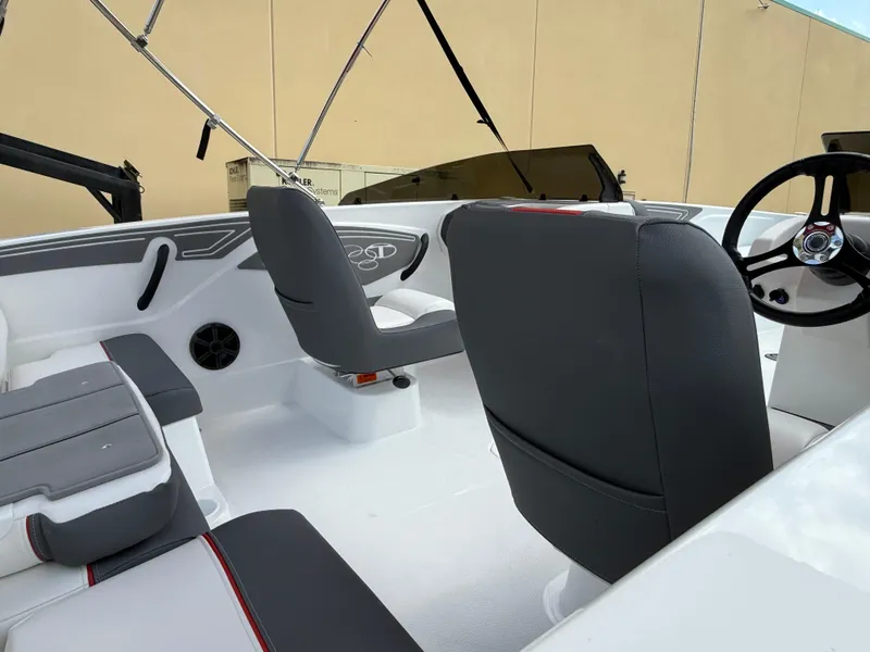 Slide: The Image of 2025 Tahoe T21 boat interior with gray seating and steering wheel. - 2