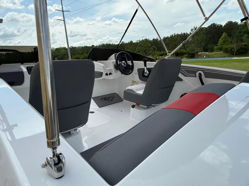 Slide: The Image of 2025 Tahoe T21 boat interior with gray and red seating, steering wheel, and open canopy. - 3