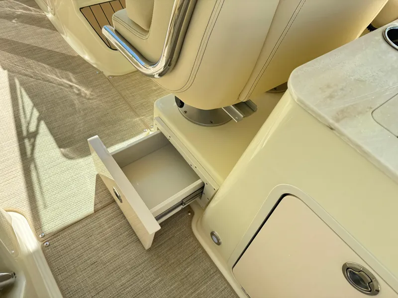 Slide: The Image of 2025 Chris-Craft Calypso 28 interior with open storage drawer and seating. - 19