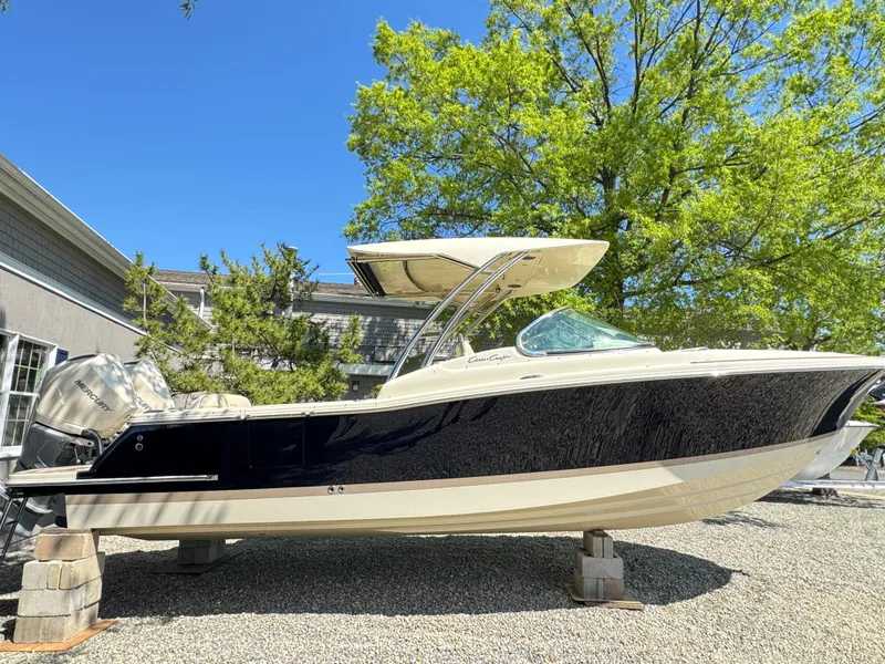 Slide: The Image of 2025 Chris-Craft Calypso 28 boat on display, outdoors, under clear blue sky. - 2