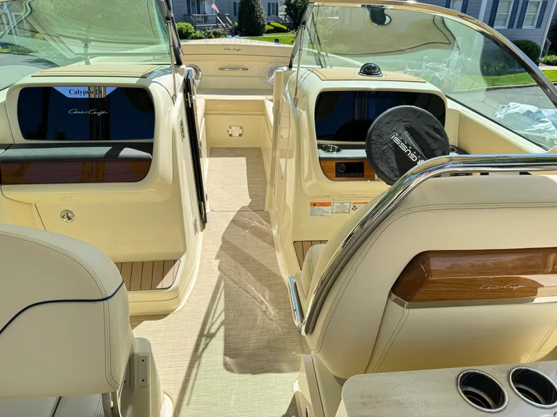 Slide: The Image of 2025 Chris-Craft Calypso 28 boat interior with beige seating and wooden accents. - 20