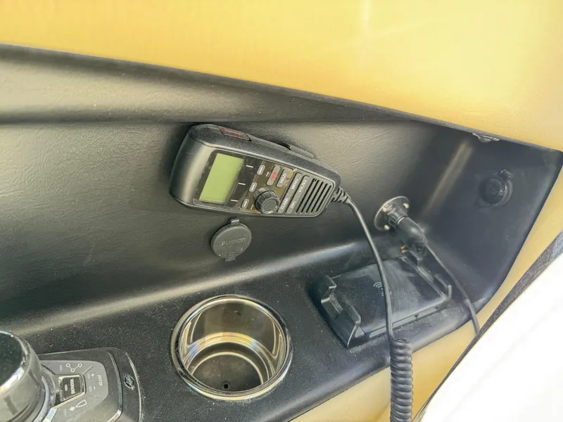 Slide: The Image of 2025 Chris-Craft Calypso 28 dashboard with radio and cup holder. - 25