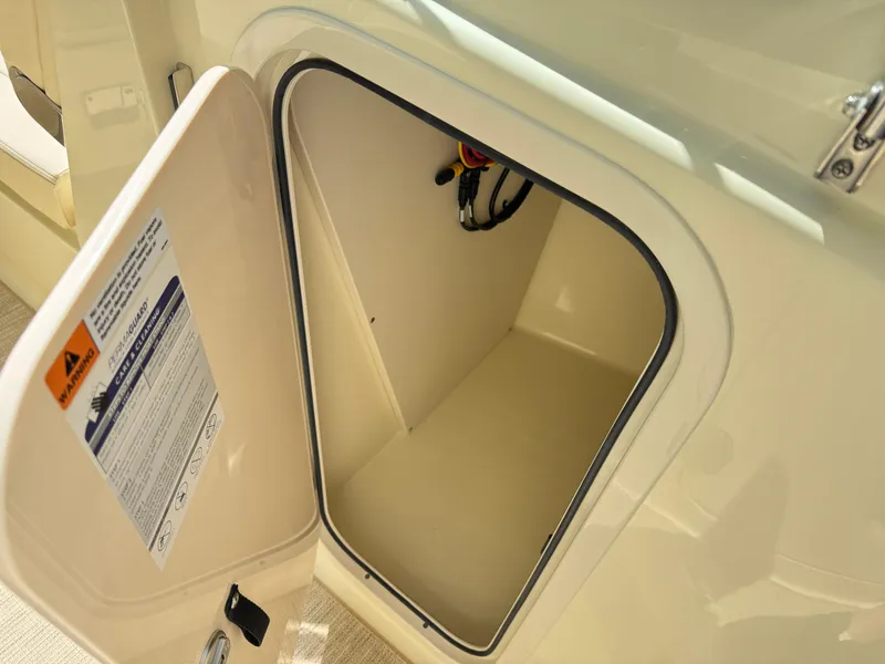 Slide: The Image of Storage compartment on 2025 Chris-Craft Calypso 28 boat, open door, beige interior. - 28