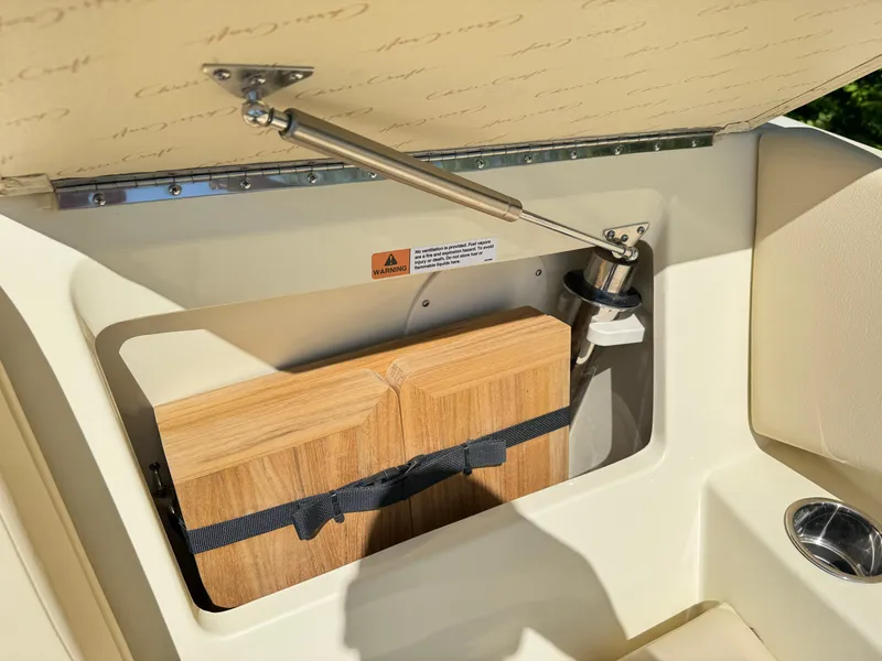 Slide: The Image of 2025 Chris-Craft Calypso 28 storage compartment with cutting board and hydraulic lift. - 30