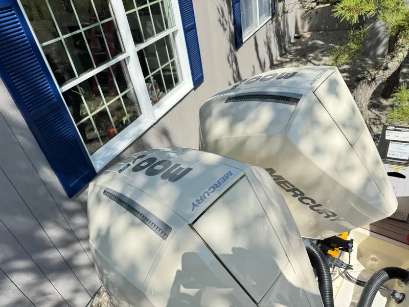 Slide: The Image of Twin Mercury outboard engines on a 2025 Chris-Craft Calypso 28, near a house with blue shutters. - 4