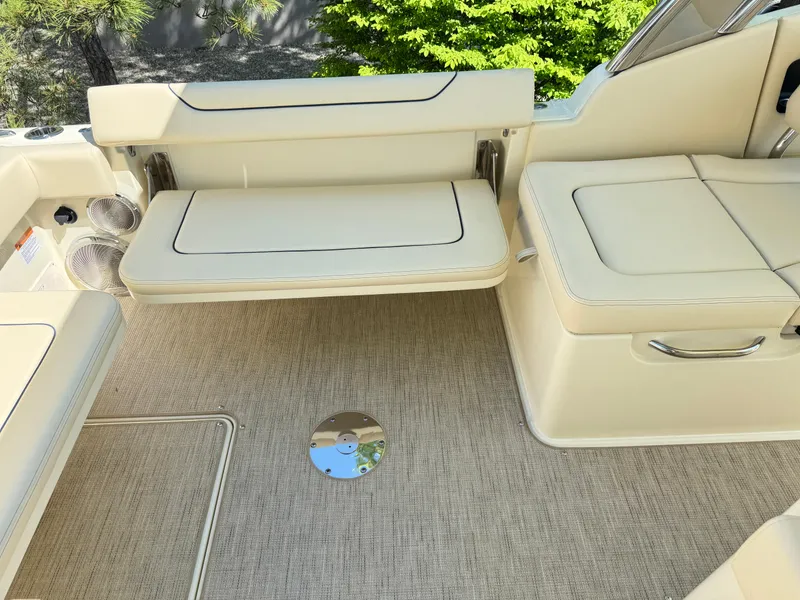 Slide: The Image of 2025 Chris-Craft Calypso 28 interior with beige seating and carpeted flooring. - 8