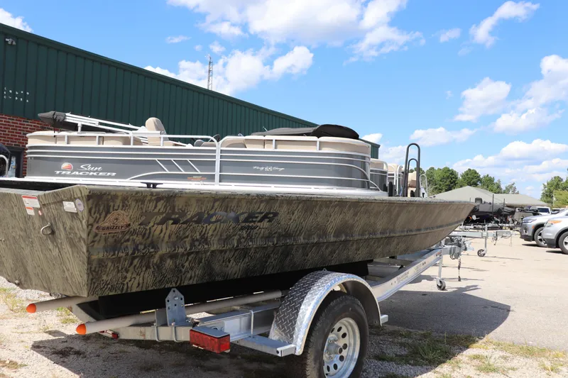 Slide: The Image of 2025 Tracker Grizzly 1860 Utility boat on trailer, outdoors under blue sky. - 3