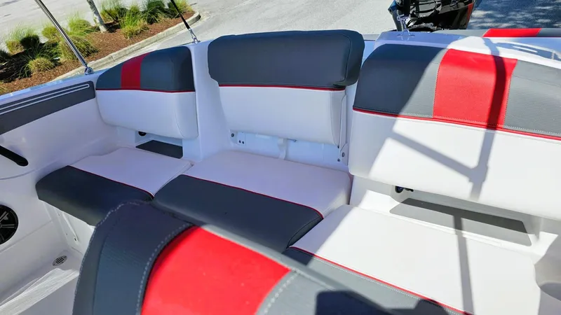 Slide: The Image of 2025 Tahoe T21 boat interior with gray and red cushioned seating. - 10
