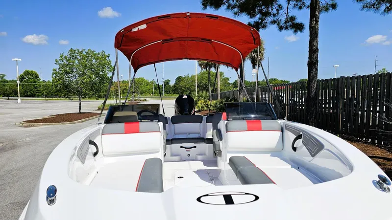 Slide: The Image of 2025 Tahoe T21 boat with red canopy, parked outdoors on a sunny day. - 11
