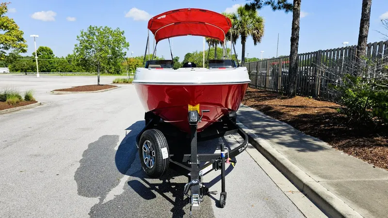 Slide: The Image of 2025 Tahoe T21 boat with red canopy on a trailer, parked on a sunny street. - 5