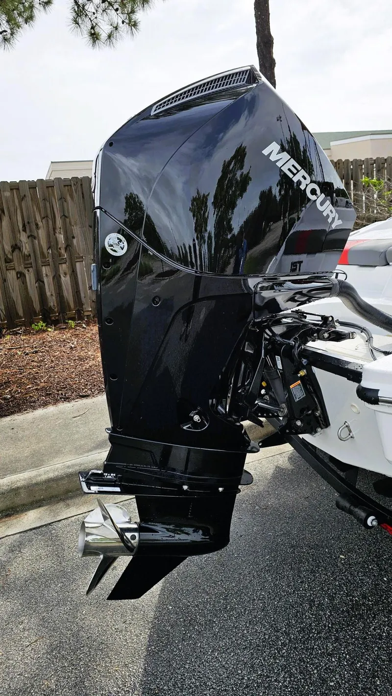 Slide: The Image of 2025 Tahoe T21 boat with a Mercury outboard motor, parked outdoors. - 13