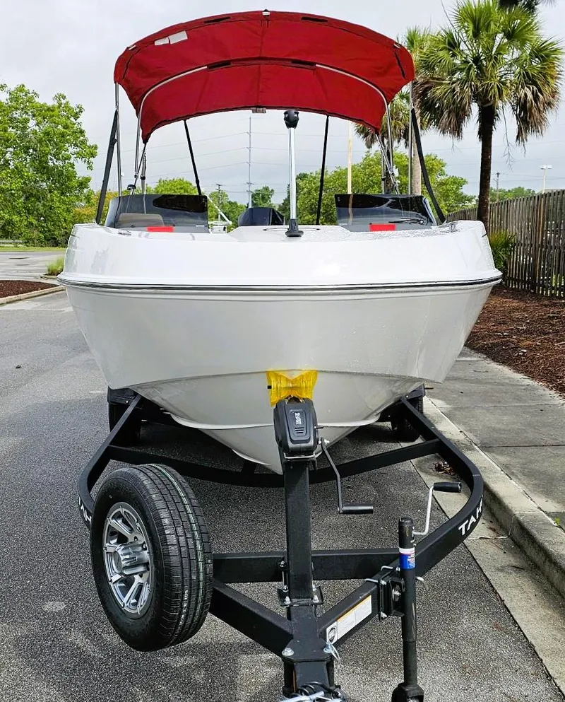 Slide: The Image of 2025 Tahoe T21 boat with red canopy on trailer, parked near palm trees. - 6