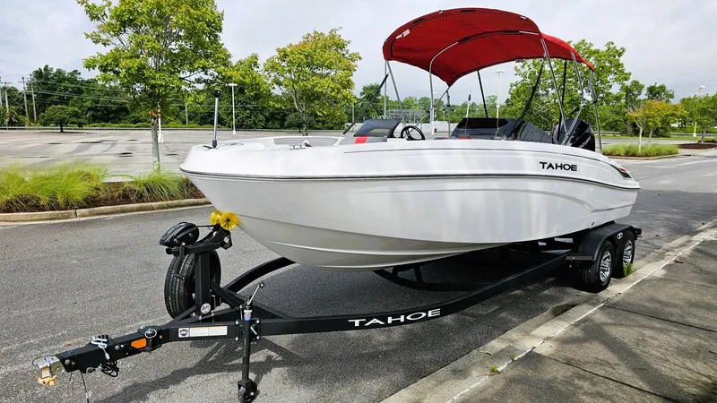 Slide: The Image of 2025 Tahoe T21 boat with red canopy on trailer in parking lot. - 7