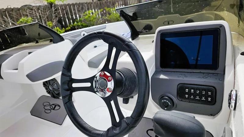 Slide: The Image of Steering wheel and dashboard of 2025 Tahoe T21 boat, featuring modern controls and display. - 9