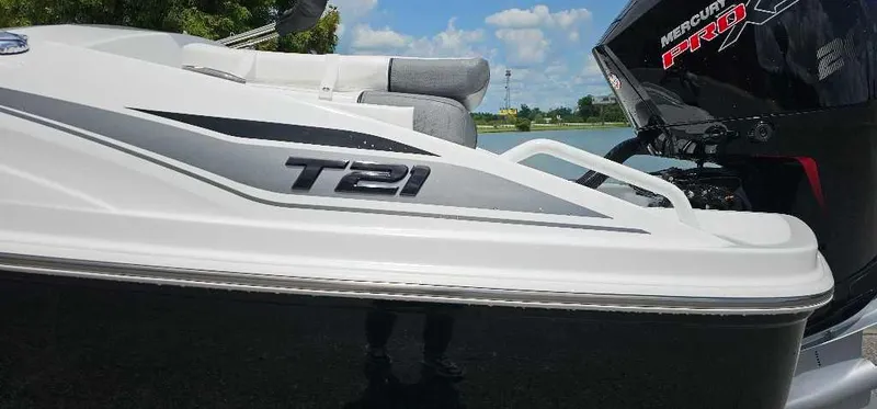 Slide: The Image of 2025 Tahoe T21 boat with sleek design and Mercury engine, set against a sunny backdrop. - 2