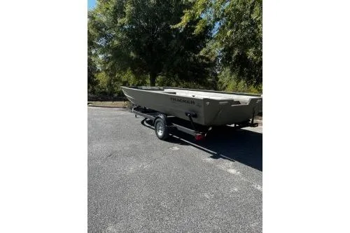 Slide: The Image of 2025 Tracker Grizzly 1860 Utility boat on trailer, parked outdoors. - 2