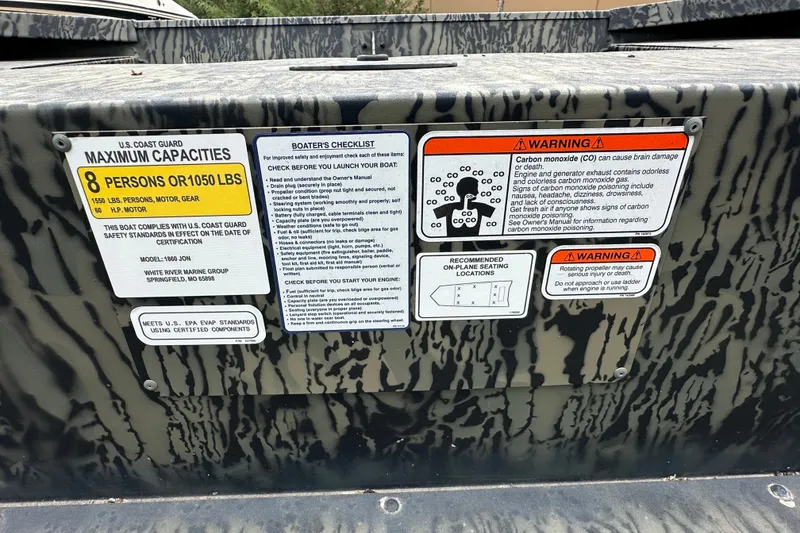 Slide: The Image of 2025 Tracker Grizzly 1860 Utility boat capacity and safety warning labels. - 21