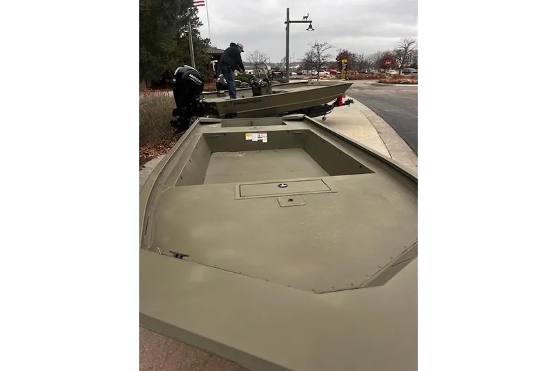 Slide: The Image of 2025 Tracker Grizzly 1860 Utility boat on trailer, parked outdoors. - 18