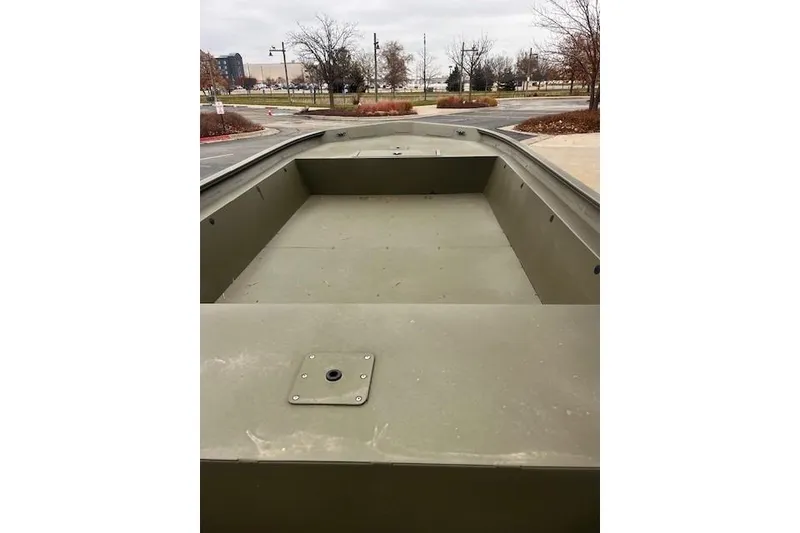 Slide: The Image of 2025 Tracker Grizzly 1860 Utility boat, empty interior view, parked outdoors. - 19