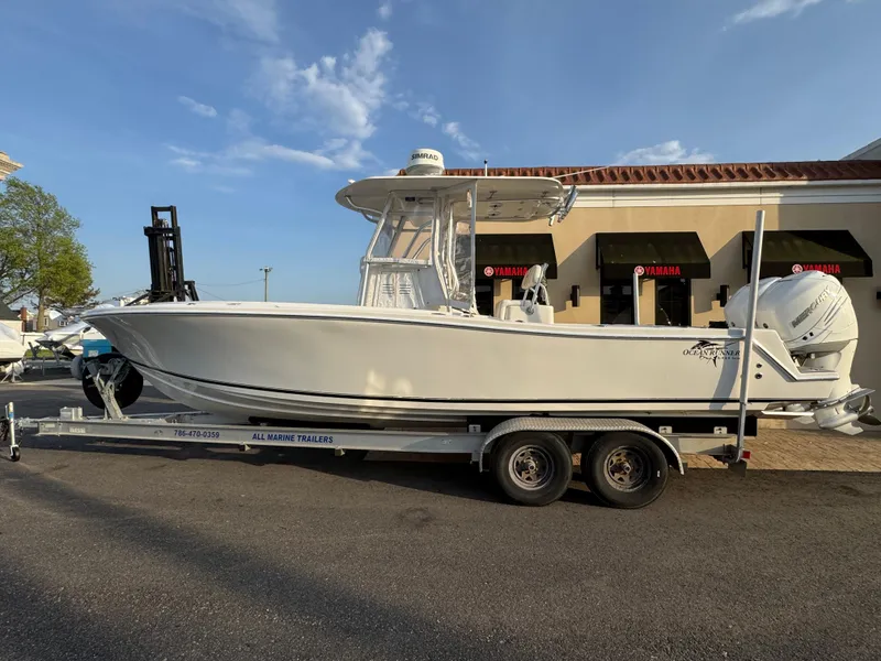 The Image of 2015 Ocean Runner 2900 boat on trailer, parked outside a building under a clear sky. - 1