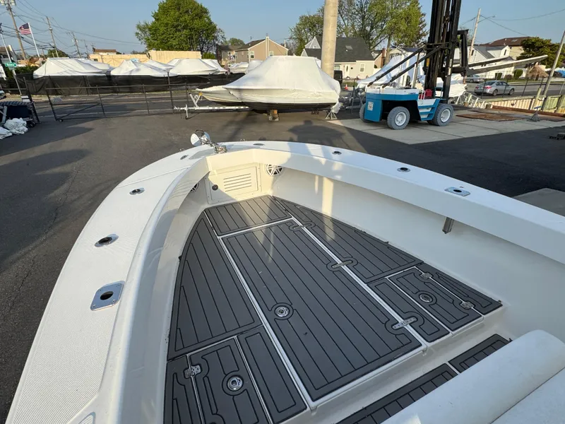 Slide: The Image of 2015 Ocean Runner 2900 boat deck with gray flooring, docked in a marina. - 13