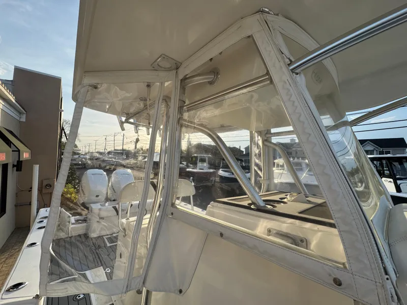 Slide: The Image of 2015 Ocean Runner 2900 boat with clear enclosure and twin engines at dock. - 16