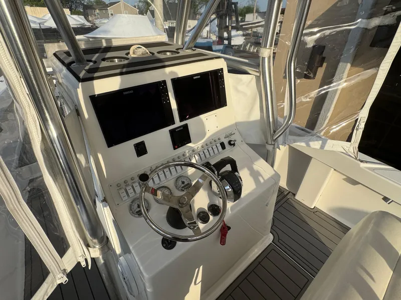 Slide: The Image of Control console of a 2015 Ocean Runner 2900 boat with dual screens and steering wheel. - 4