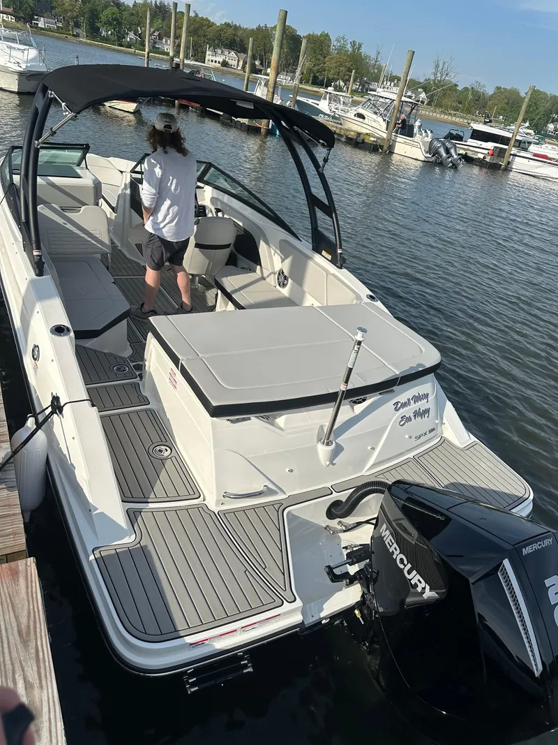 Slide: The Image of 2024 Sea Ray 230SPX boat docked, featuring a spacious deck and Mercury engine. - 6