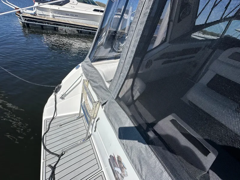 Slide: The Image of 1990 Sea Ray 310 Sundancer docked, featuring deck and cabin enclosure. - 12