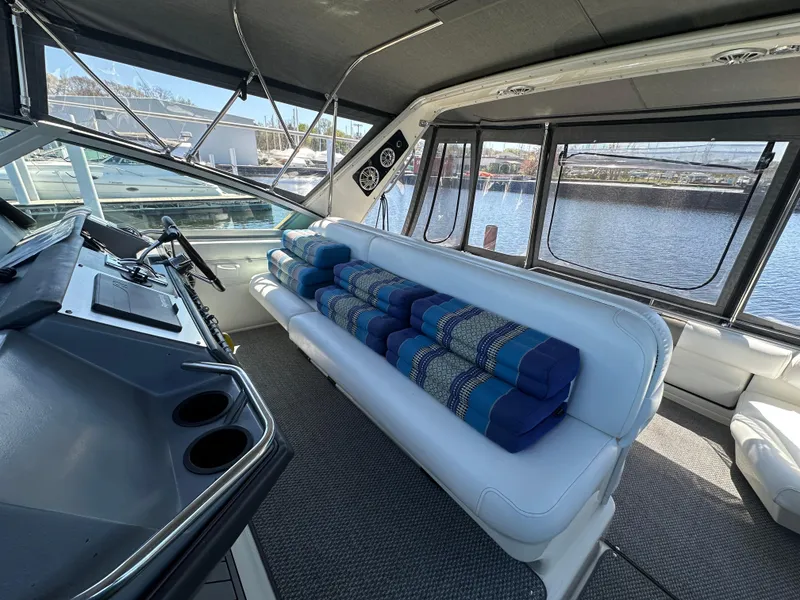 Slide: The Image of Interior of 1990 Sea Ray 310 Sundancer with white seating and blue cushions. - 16