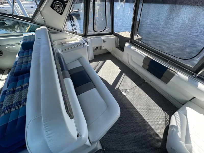 Slide: The Image of 1990 Sea Ray 310 Sundancer interior with white seating and lake view. - 17