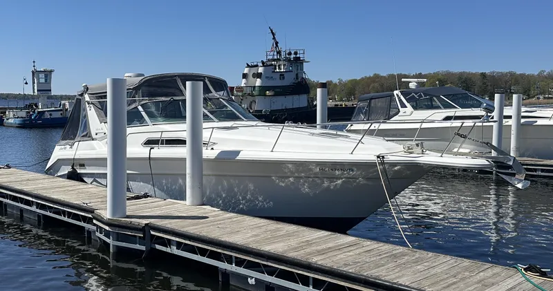 Slide: The Image of 1990 Sea Ray 310 Sundancer docked at marina, clear sky, calm water. - 2