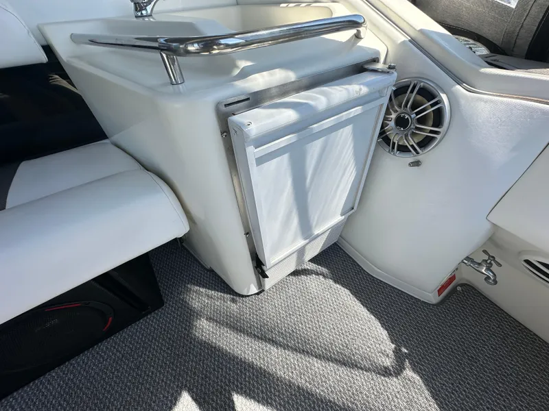 Slide: The Image of 1990 Sea Ray 310 Sundancer interior with mini fridge and speaker. - 21