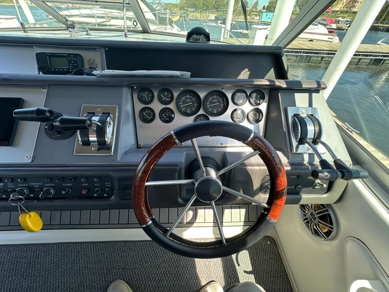 Slide: The Image of Cockpit of 1990 Sea Ray 310 Sundancer with steering wheel and control panel. - 23