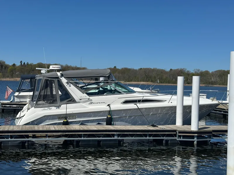 Slide: The Image of 1990 Sea Ray 310 Sundancer docked on a sunny day, surrounded by calm water. - 3